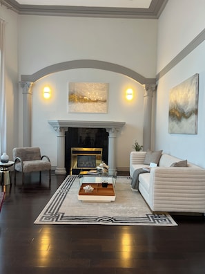 A living room with a fireplace, two armchairs, a sofa, and a coffee table. - Haidian Mama Garden Suite (Richmond)