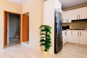 A modern kitchen with a built-in refrigerator, white cabinets, and a potted plant. - Puerto Plata City Stay (Puerto Plata)