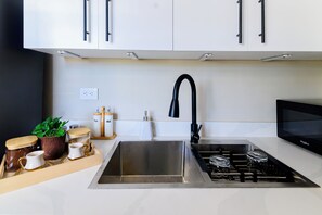 A modern kitchen with stainless steel appliances, a sink, and cabinets. - Puerto Plata City Stay (Puerto Plata)