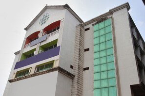 A multi-story building with balconies and large windows.