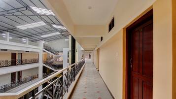 A multi-level corridor with a staircase on the left and a door on the right.