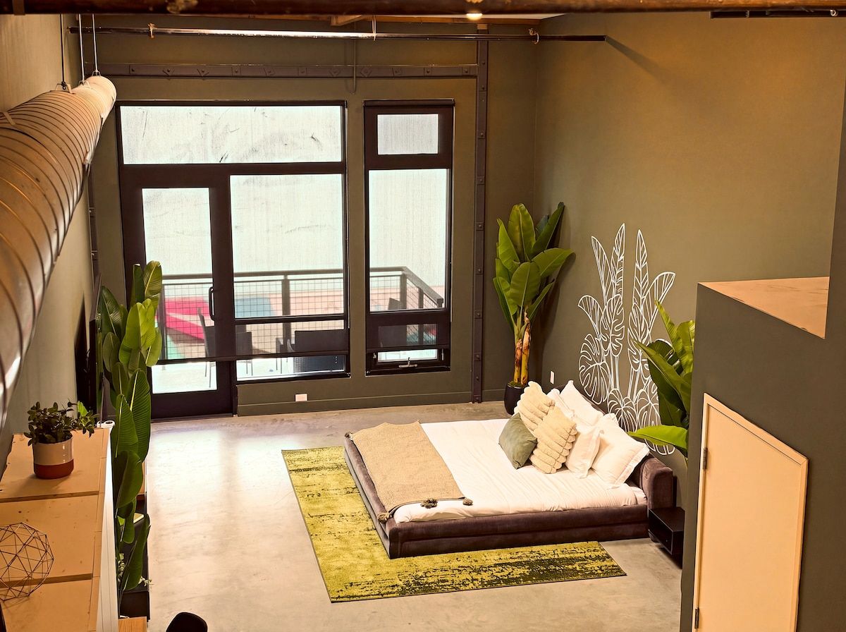 A modern bedroom with a bed, a large window, and a view of the outside.