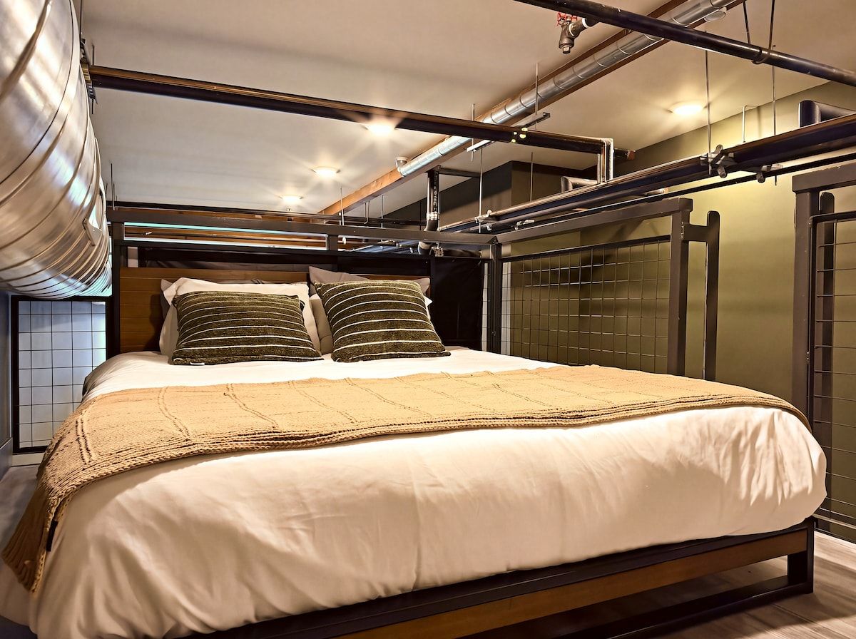A modern bedroom with a bed, pillows, and a headboard.