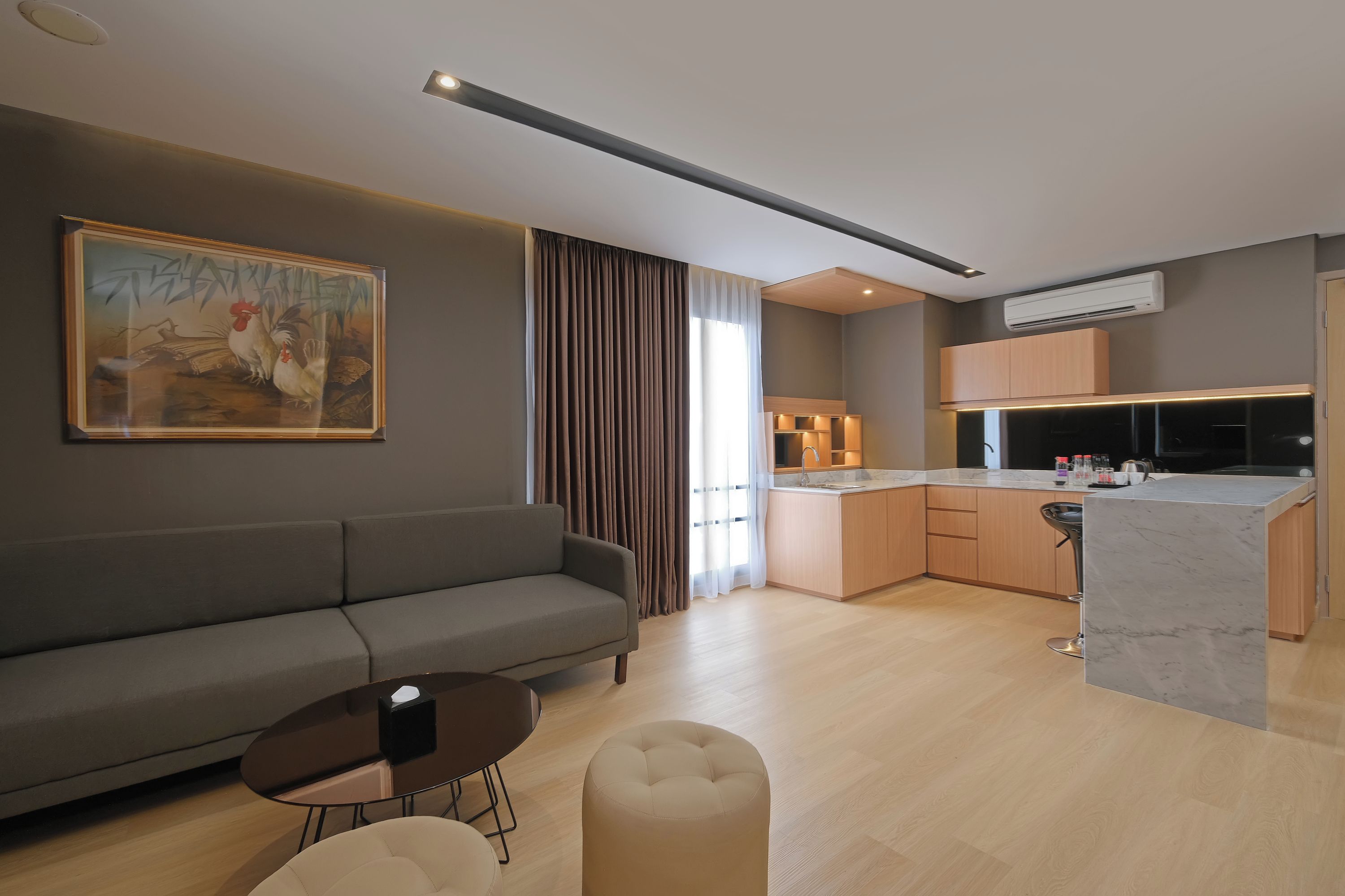 Una sala de estar moderna con un sofá, una mesa redonda y un cuadro en la pared.