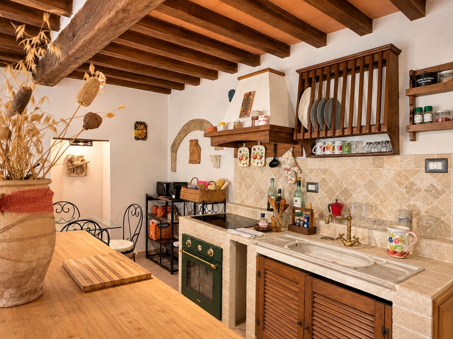 Una cucina con piano di lavoro in legno, forno incassato e rastrelliera pensile per stoviglie.