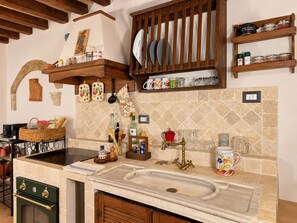 A kitchen with a built-in oven, a sink, and various kitchen utensils and appliances.