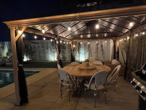 An outdoor patio with a round table and chairs, a grill, and a pool. -     Resort-Style Desert Oasis + Pool & Spa (Bermuda Dunes)