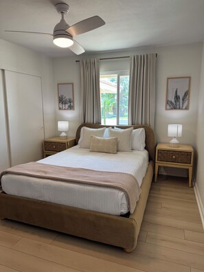 A bedroom with a bed, two bedside tables, a ceiling fan, and a window with curtains. -     Resort-Style Desert Oasis + Pool & Spa (Bermuda Dunes)