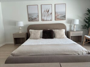 A bedroom with a bed, two bedside tables, a lamp, a chair, and three framed pictures on the wall. -     Resort-Style Desert Oasis + Pool & Spa (Bermuda Dunes)