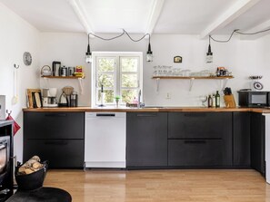 A modern kitchen with a dishwasher, wooden countertop, and a large window. - Guttamåla by Interhome (Tving)