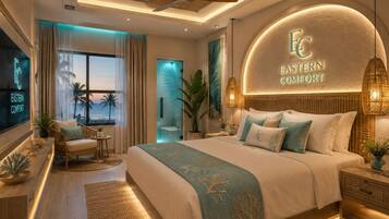 Une chambre moderne avec un grand lit, un ventilateur de plafond et une vue sur l’océan.
