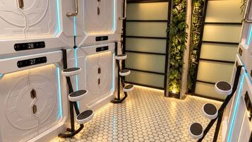 Un espace de spa moderne doté d’un sol à motifs hexagonaux, de cabines de massage murales et d’un éclairage d’ambiance.