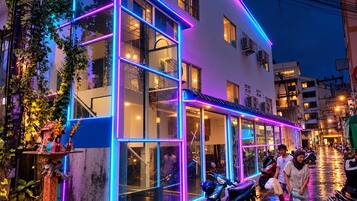 Un bâtiment doté de nombreuses fenêtres et dont l’extérieur est illuminé par des néons.