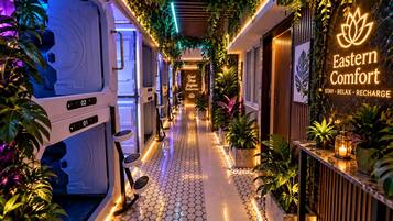 Un couloir avec une enseigne indiquant « Eastern Comfort Stay Relax Recharge » et une rangée de coins salon.