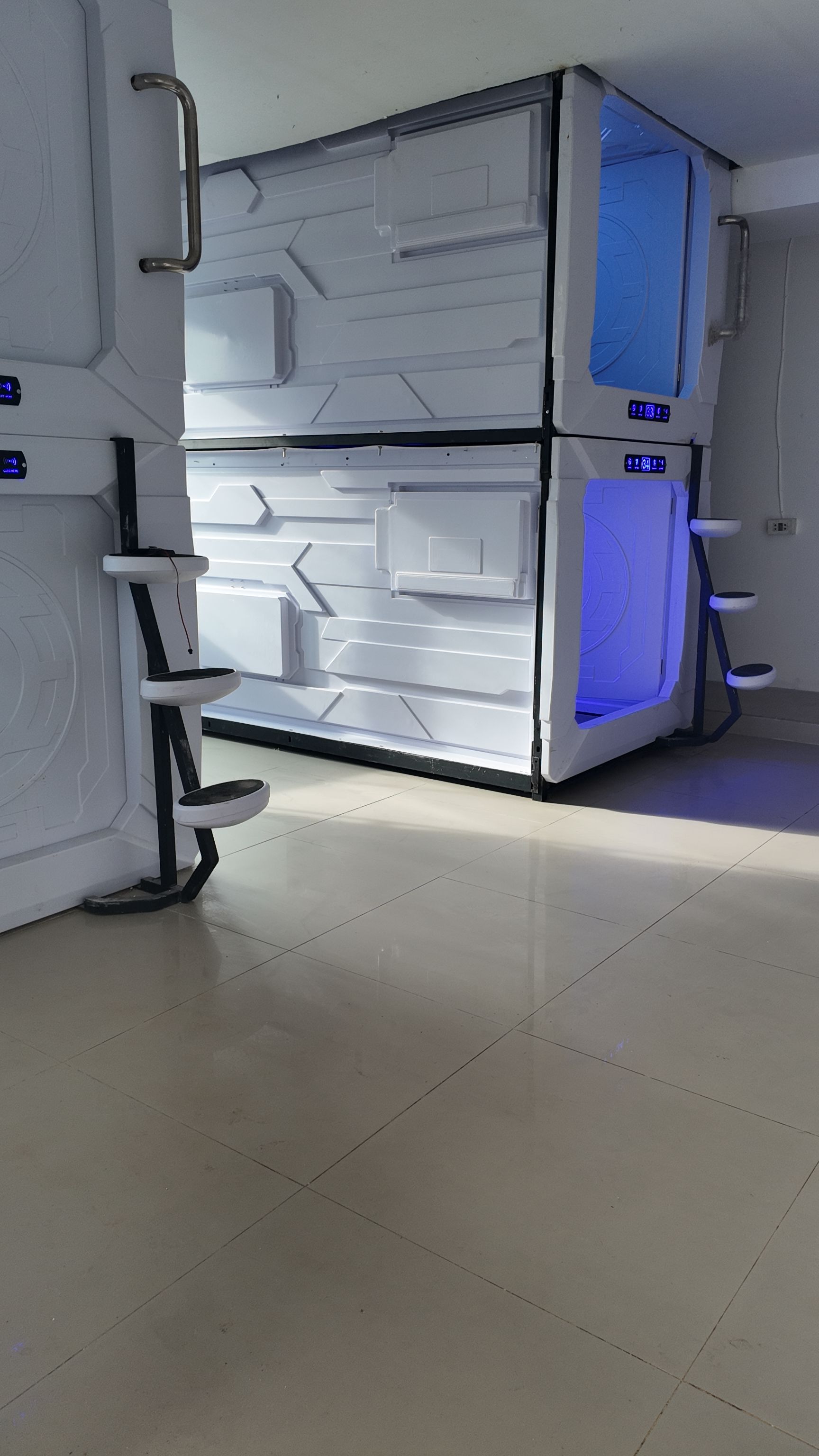 Un réfrigérateur moderne, blanc, à deux niveaux, doté d’un écran numérique, situé dans une pièce dont le sol est carrelé.