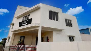A modern two-story building with a flat roof, a balcony, and a sign that reads 'Collection.'