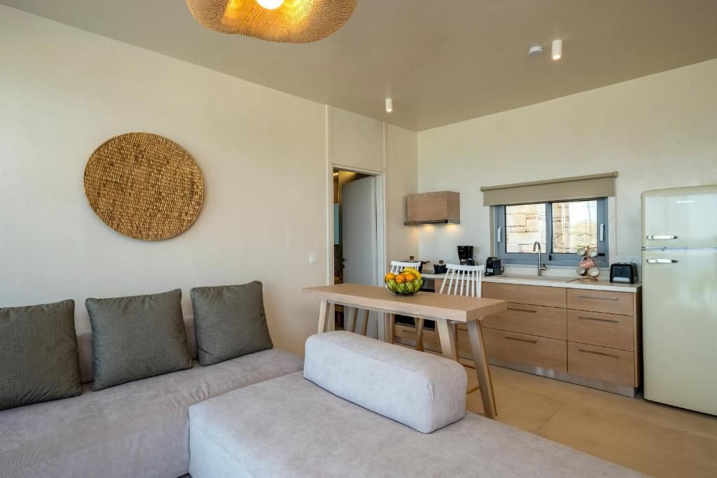 A modern living space with a sofa, a dining table, and a kitchen area.