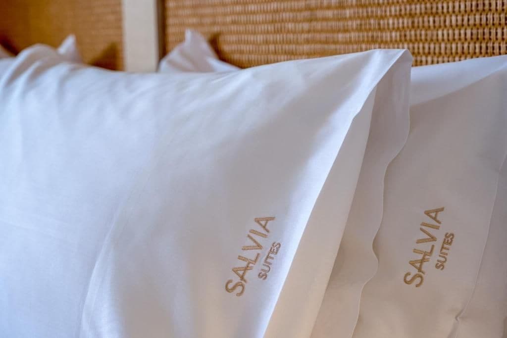 A white pillow with the text 'SALVIA SUITES' printed on it.