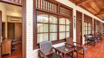 A corridor with wooden furniture and large windows with curtains.