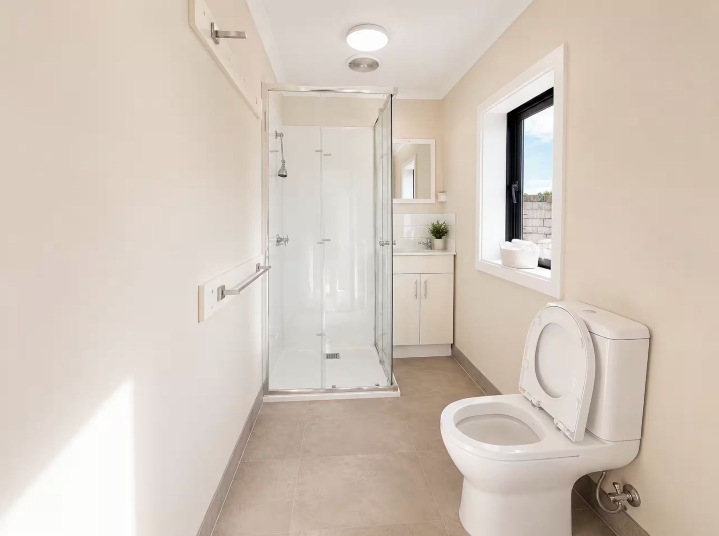 Ein Badezimmer mit Toilette, Duschkabine und Fenster.