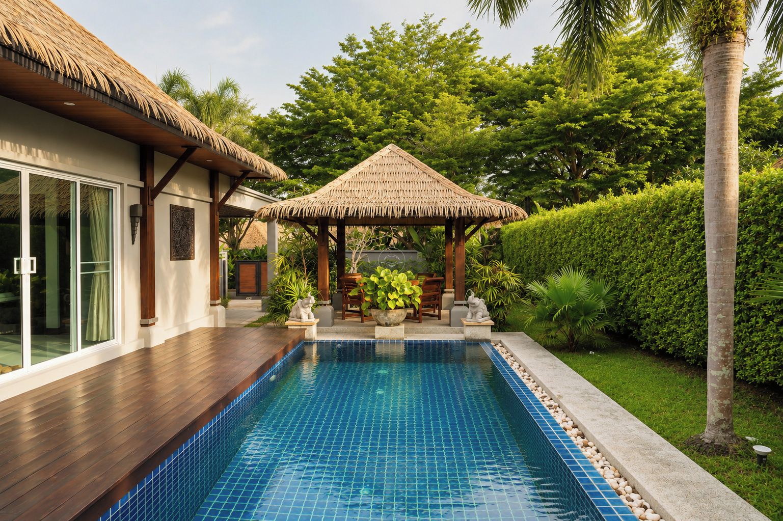 A swimming pool with a tiled edge, a thatched-roof gazebo, and a wooden deck.