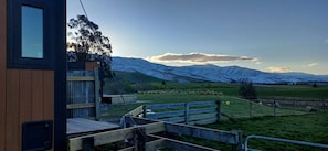 Una terraza de madera con vistas a montañas nevadas.