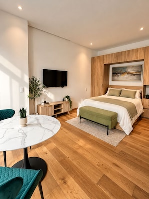 A modern bedroom with a bed, a TV, a desk, and a chair. - Comfortable apartment undergoing renovation in downtown Mexico City (Ciudad de México)