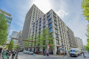 Ein mehrstöckiges Gebäude mit modernem architektonischen Design, das eine Kombination aus Balkonen und Fenstern aufweist.