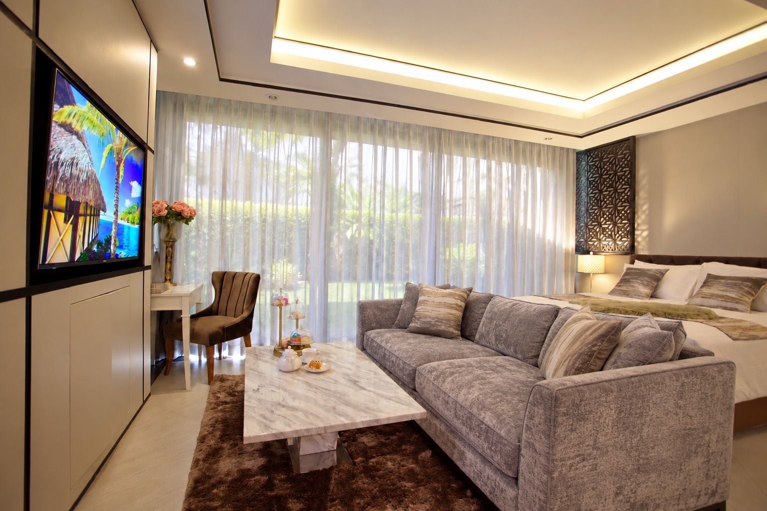 Una sala moderna con sofá, mesa de centro, televisor y un jarrón decorativo.