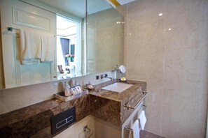 A modern bathroom with a marble countertop, a sink, a mirror, and a towel rack. - Surin Sands Phuket (Cherngtalay)