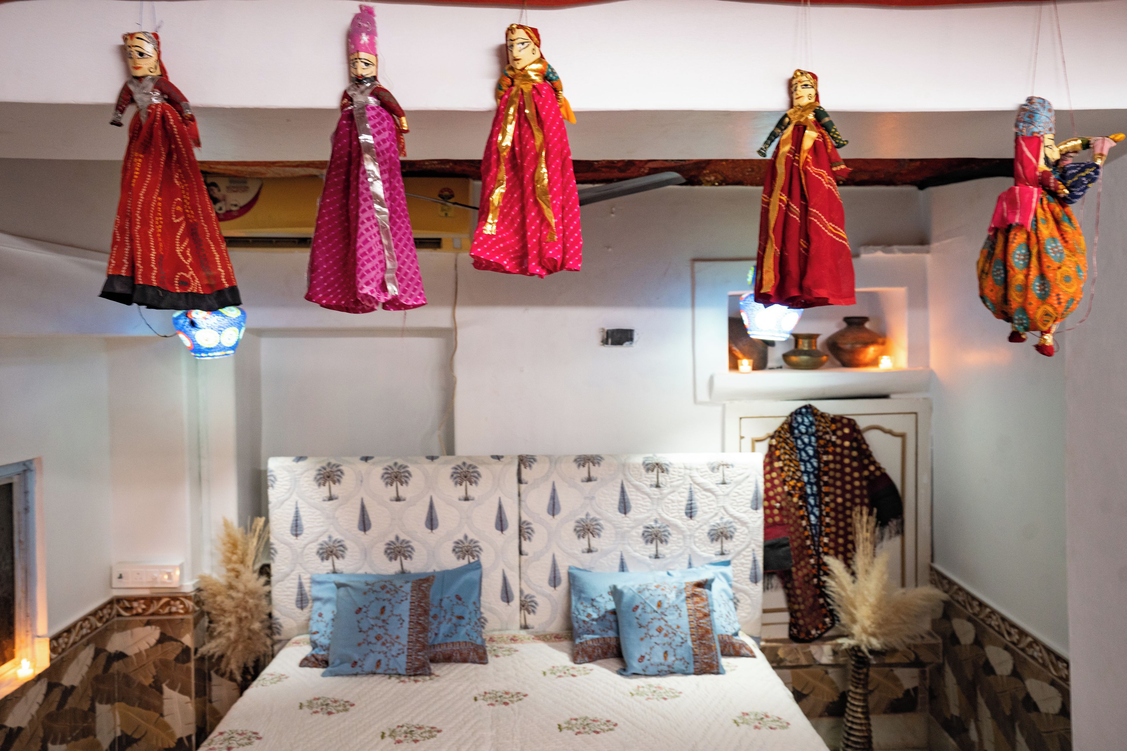 Un dormitorio con cama, almohadas y adornos colgantes.