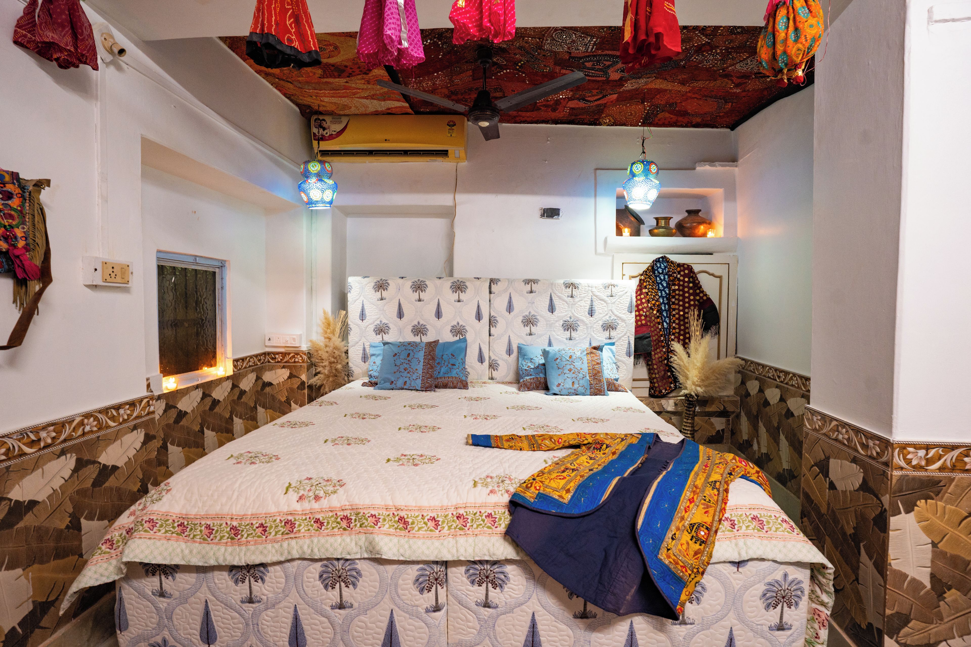 Una habitación con cama, paredes con diseño y techo decorado.