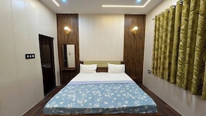 Ein Hotelzimmer mit einem Bett, einem Kleiderschrank, einem Spiegel und einer Wandleuchte.