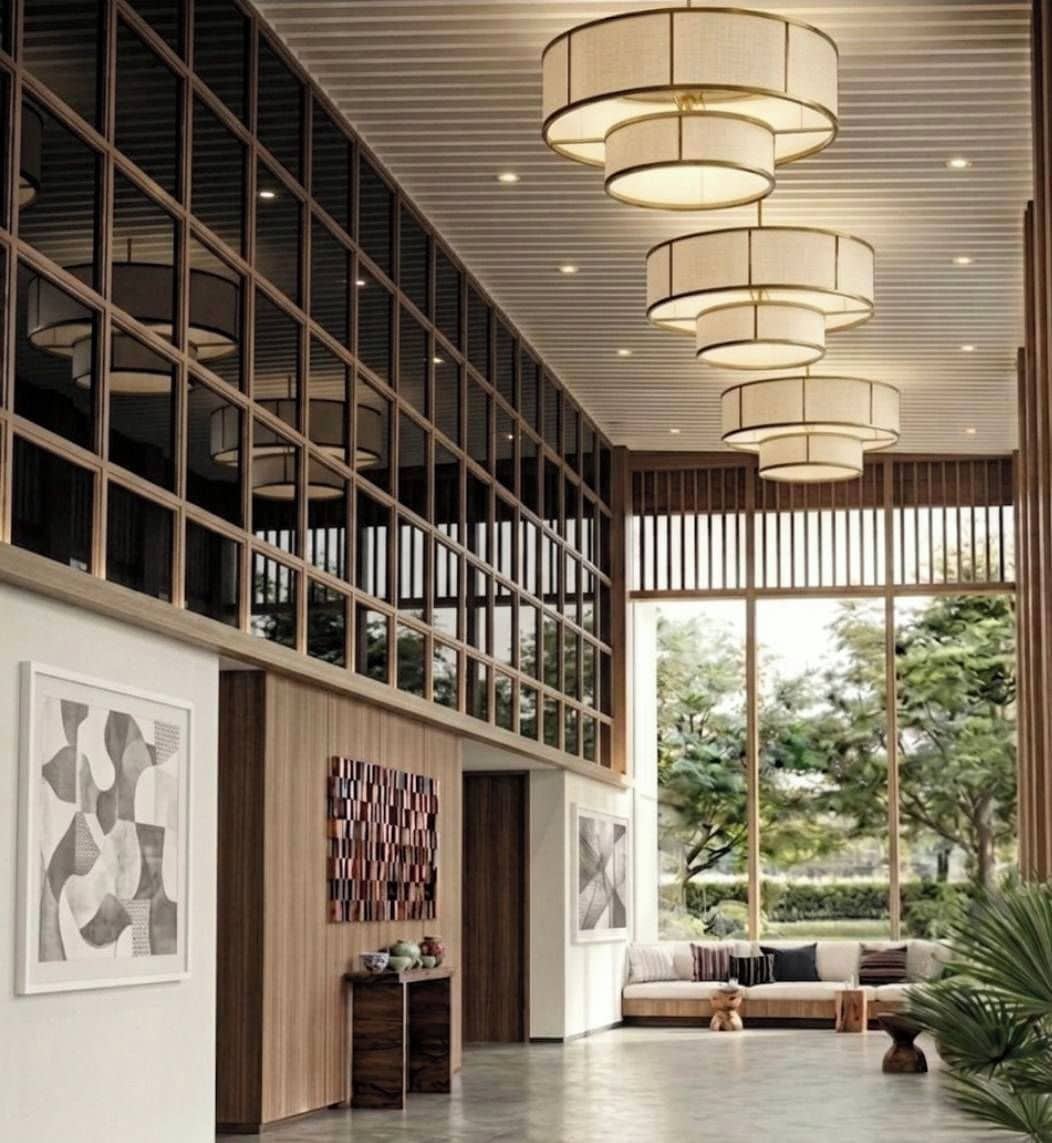 A modern interior with a large window, a sofa, and a hanging light fixture.