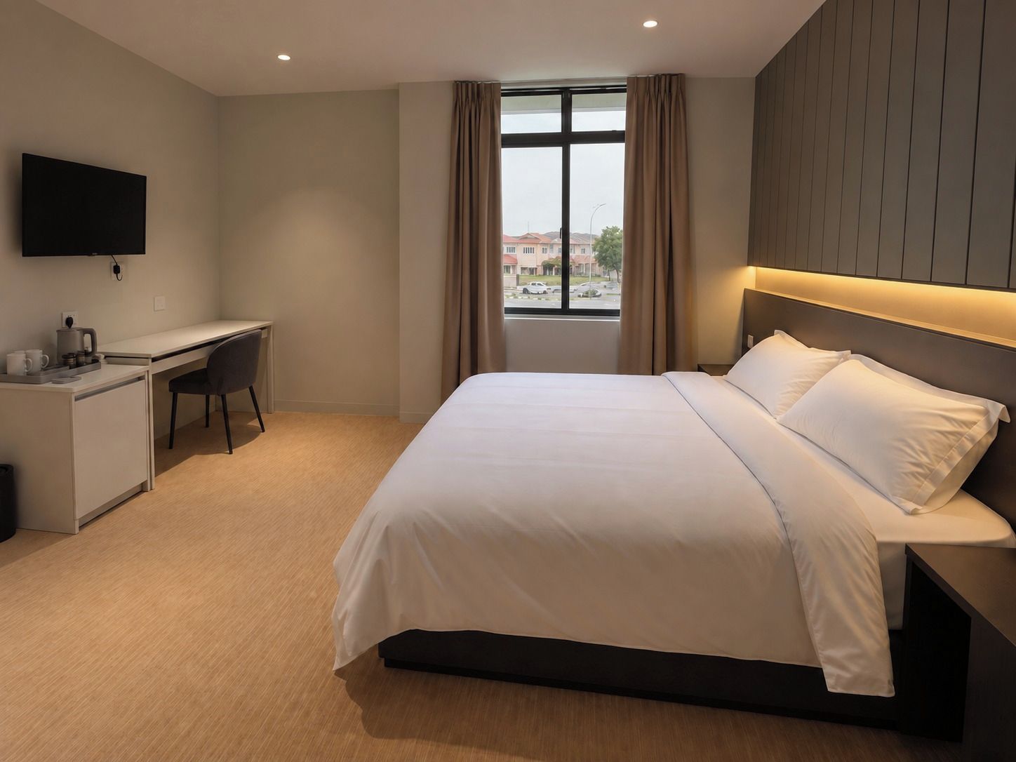 A hotel room with a bed, a desk, a chair, a television, and a window with curtains.
