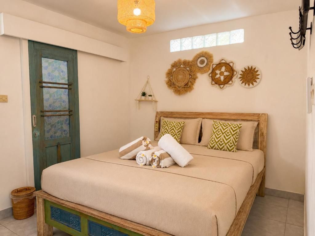 A bedroom with a bed, a door, and wall decorations.