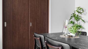 A dining area with a dark wood table, black chairs, and a potted plant.
