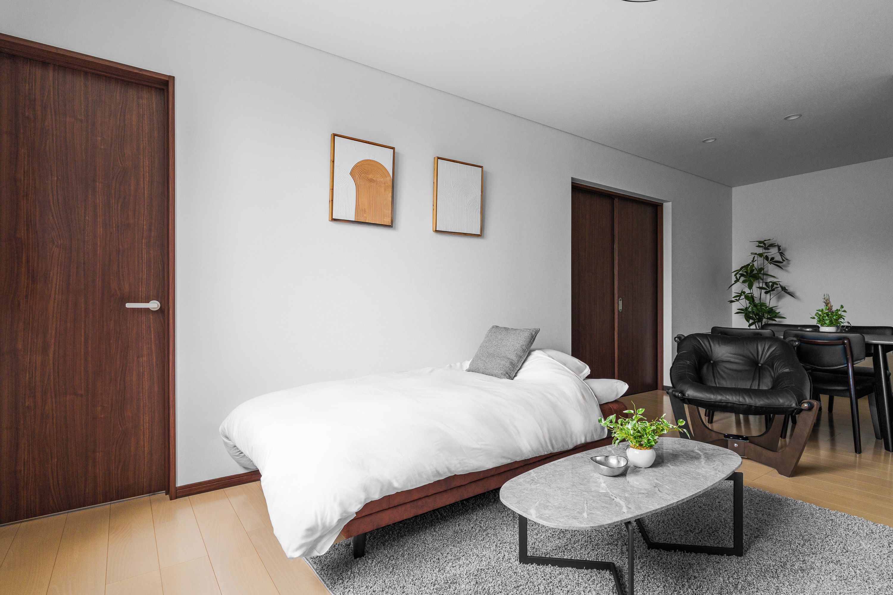 A modern bedroom with a bed, a small table, and a desk area.