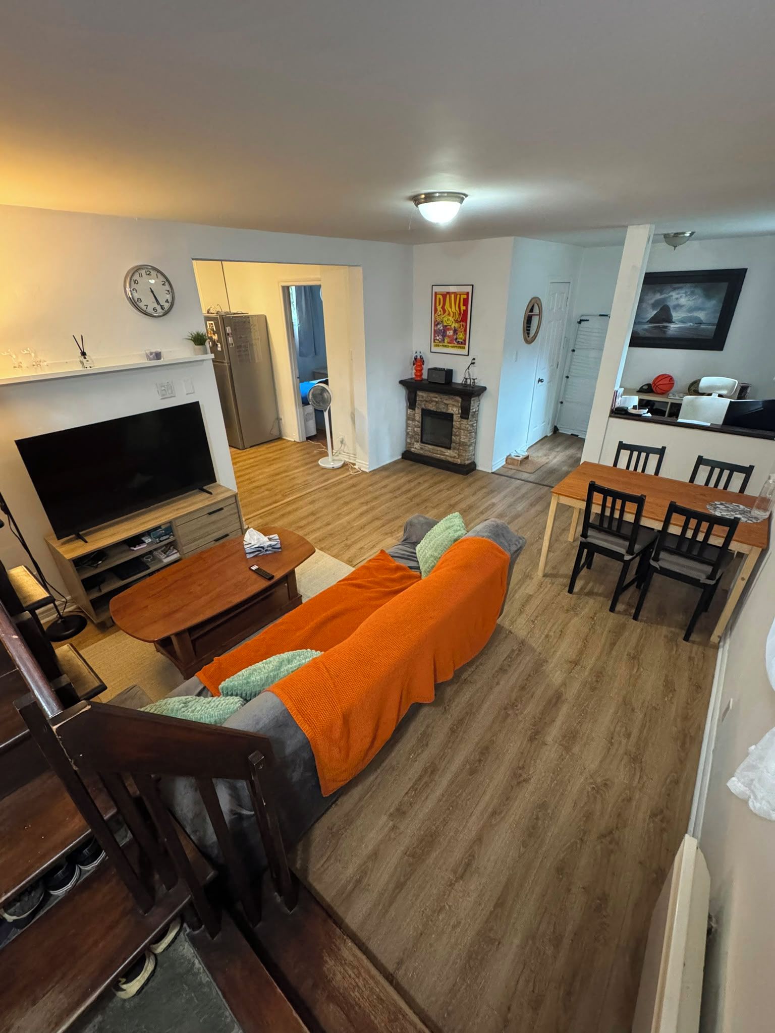 A living room with a TV, sofa, and dining area.