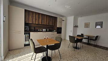 A modern kitchen with wooden cabinets, a dining area with a table and chairs, and a kitchen island.