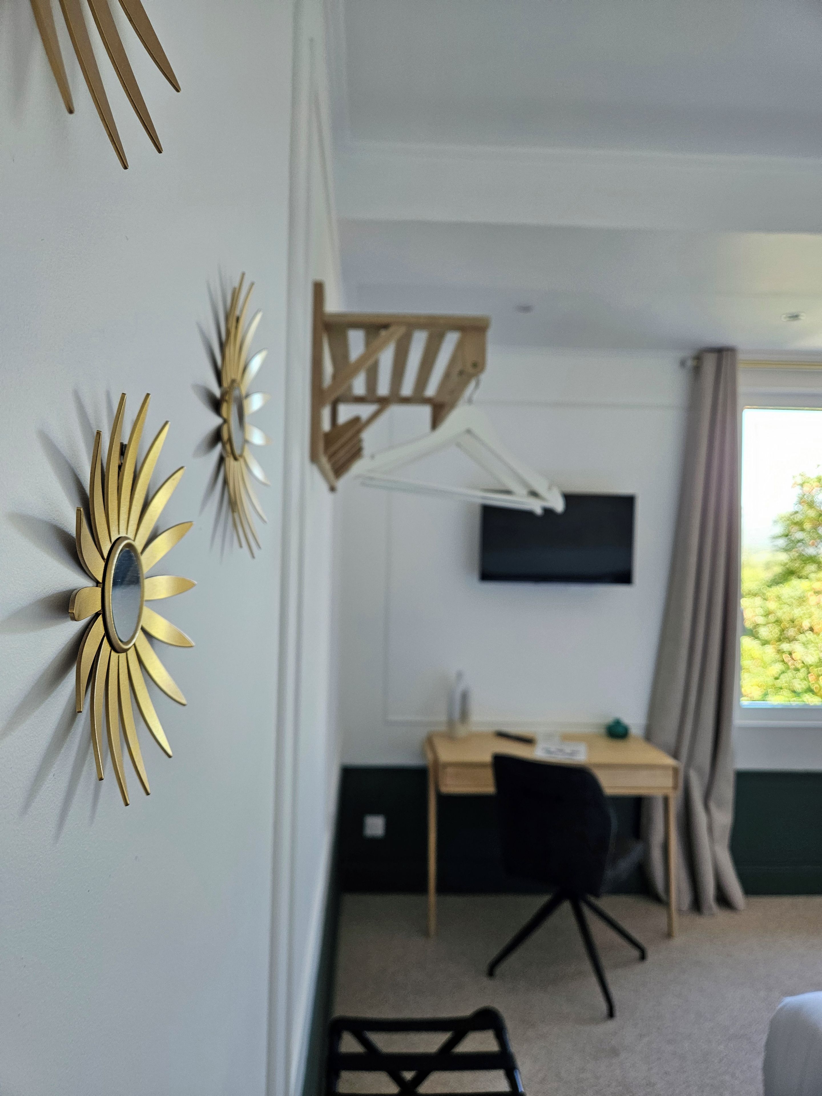 Une pièce comprenant un bureau, une chaise et un téléviseur fixé au mur.