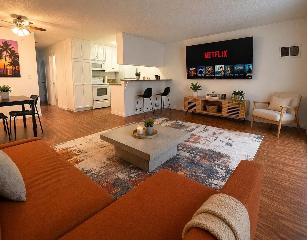 Een moderne woonkamer met een bank, salontafel en een televisie waarop Netflix wordt getoond.