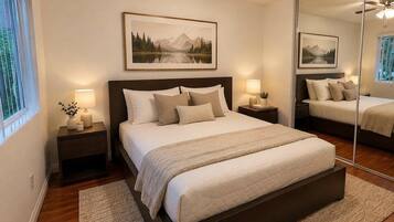 A bedroom with a large bed, two bedside tables, a ceiling fan, and a large mirror.