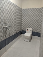 Un baño con baldosas estampadas, inodoro y zona de ducha.