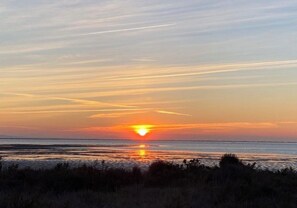 A sunset over a body of water with a clear horizon. - The Blue Tamarisk Fisherman's Cottage (Port-Saint-Louis-du-Rhône)