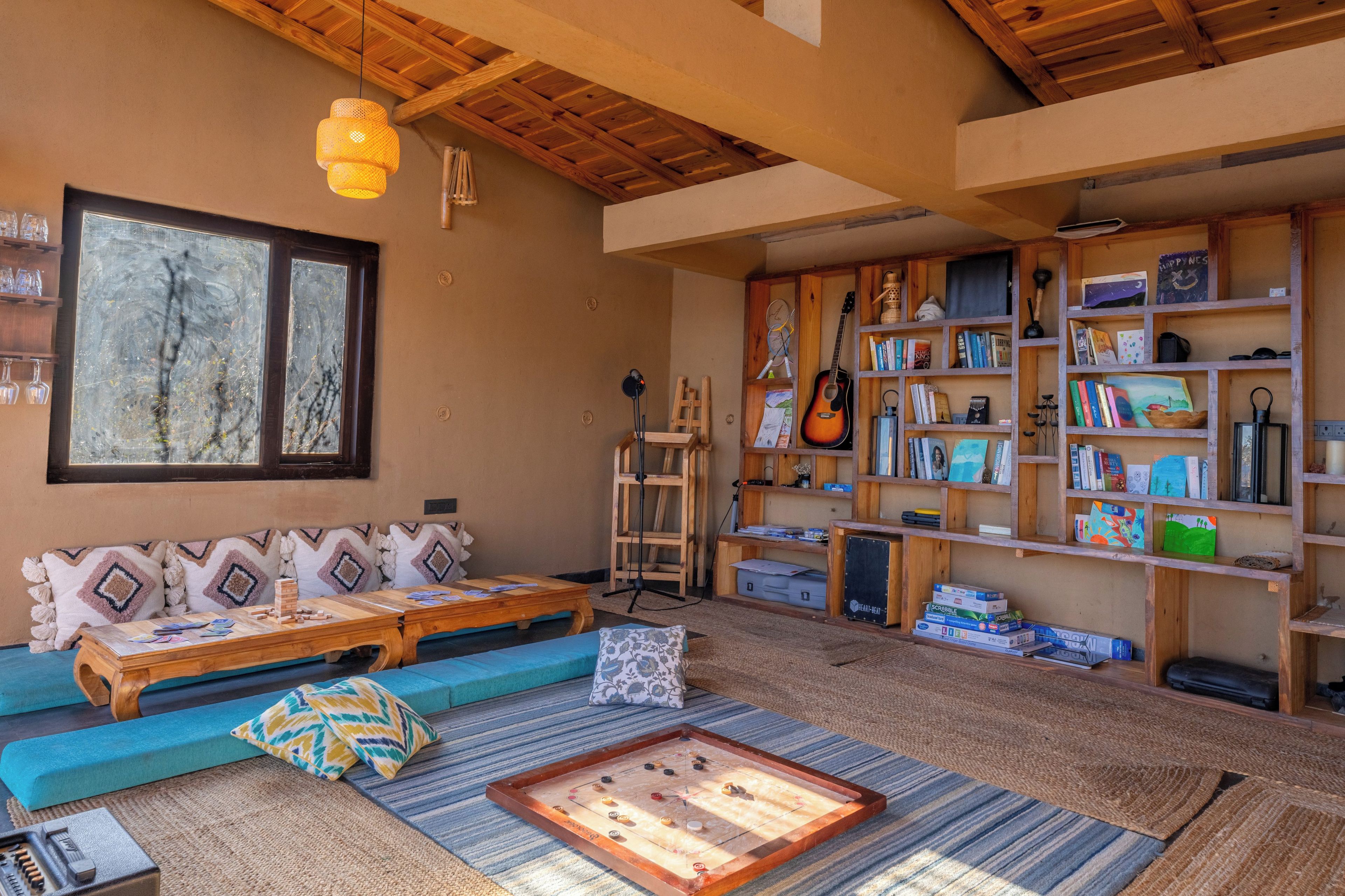 A cozy living room with a sofa, a coffee table, a bookshelf, and a foosball table.