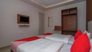 Habitación de hotel con dos camas, televisión, armario y espejo.