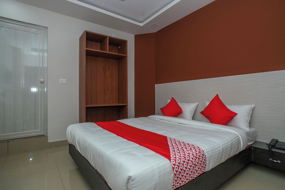 A hotel room with a bed, a wardrobe, and a nightstand.