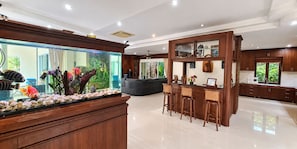 A spacious room with a large fish tank, a bar area with stools, and a seating area with a sofa. - Private 5-bedroom Pool Villa in Middle of the Island Phuket (Kathu)