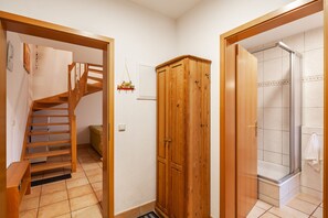 Ein Badezimmer mit Dusche, einem Holzschrank und einer Treppe.